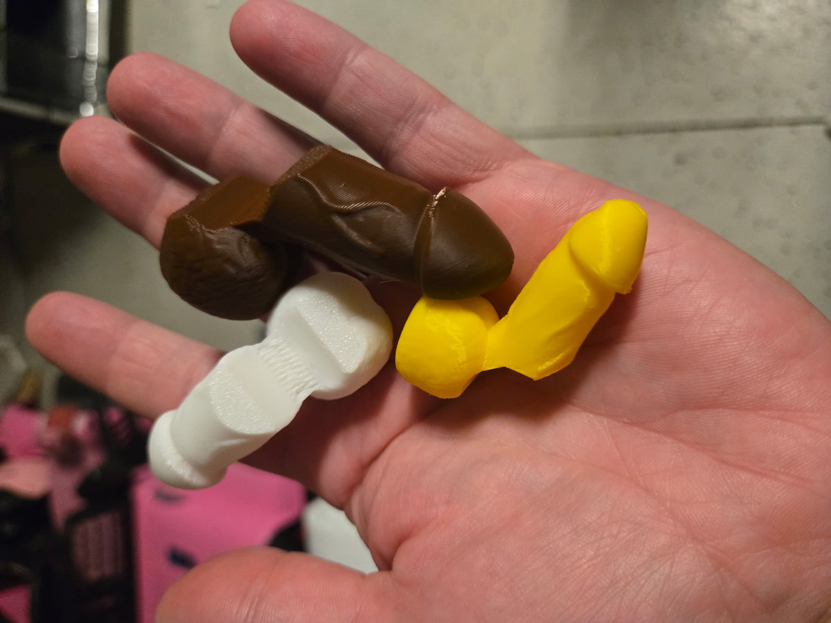Spray Daddy Trio held in a hand for scale: small yellow, medium white and large brown spray tops